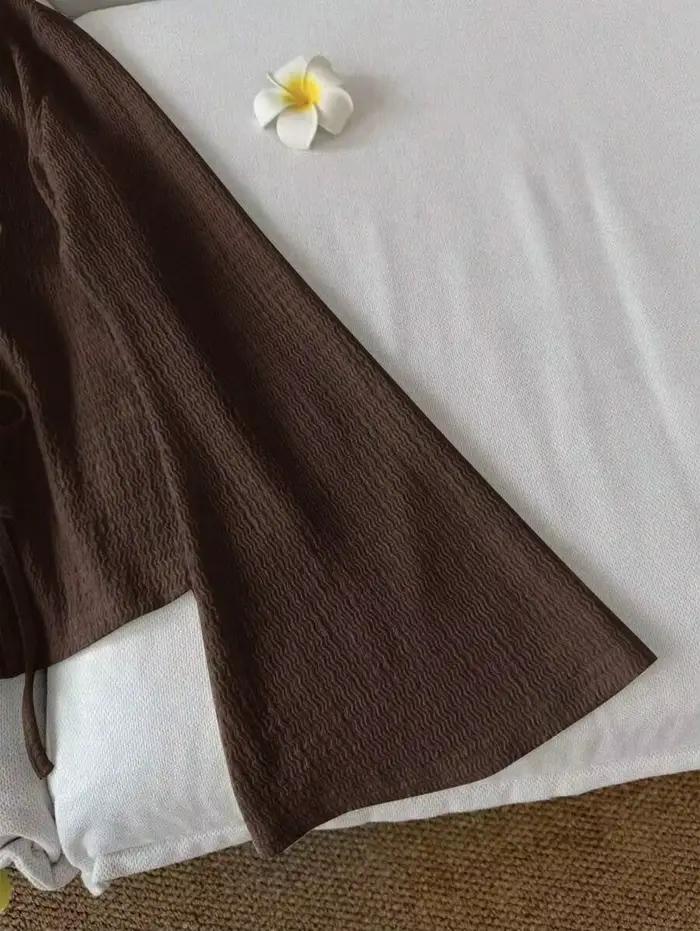 Cardigan pour femme en tissu texturé ondulé. Il présente un col en V