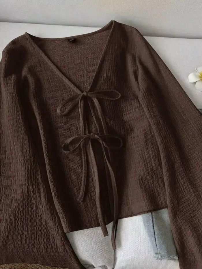 Cardigan pour femme en tissu texturé ondulé. Il présente un col en V