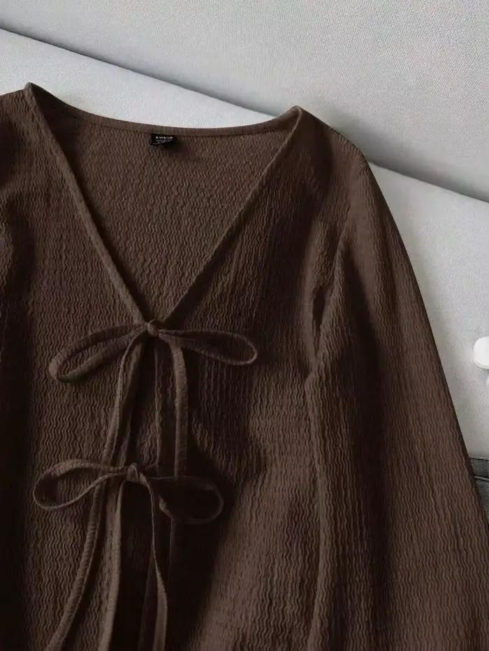 Cardigan pour femme en tissu texturé ondulé. Il présente un col en V